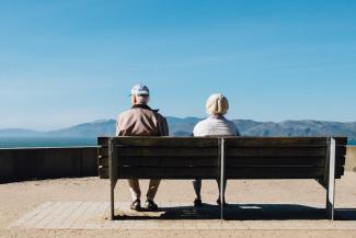 man and woman sitting on bench facing sea by Matt Bennett courtesy of Unsplash.