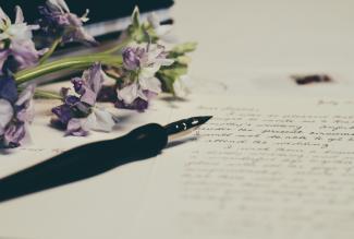 purple flowers on paper by Debby Hudson courtesy of Unsplash.