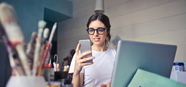 woman in white shirt using smartphone by bruce mars courtesy of Unsplash.